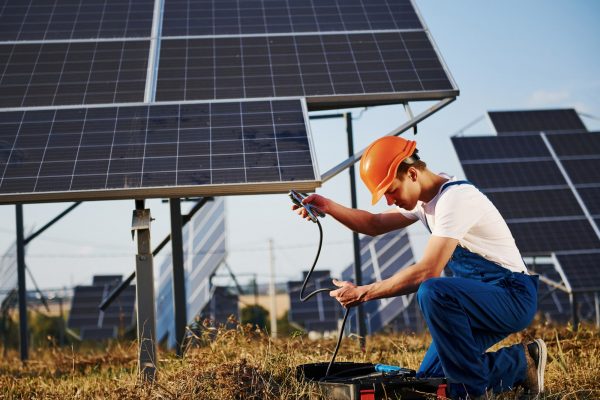 opening-case-with-equipment-male-worker-in-blue-uniform-outdoors-with-solar-batteries-at-sunny-day.jpg